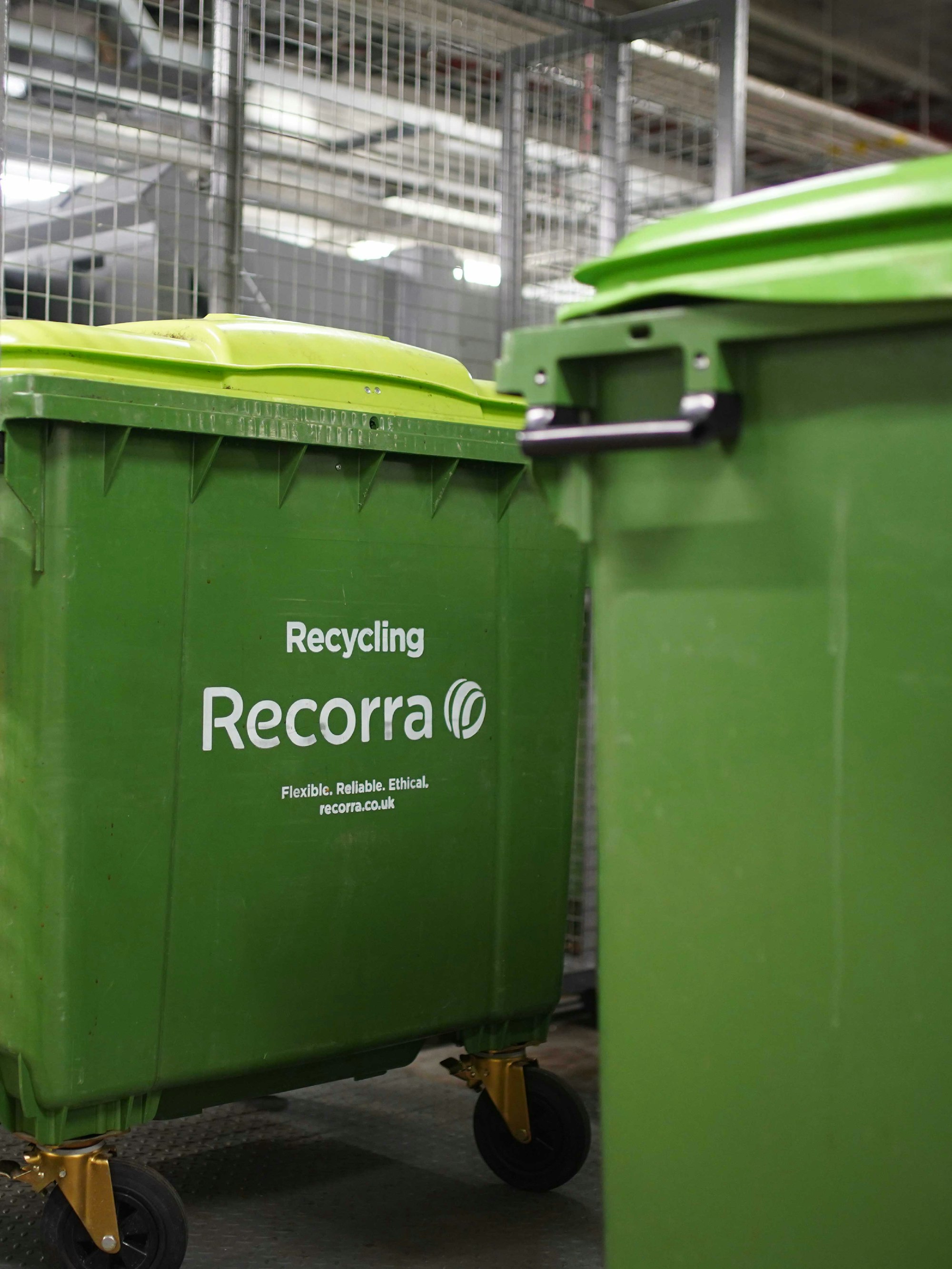 1100l wheeled green dry mixed recycling bin, inside of a store room.