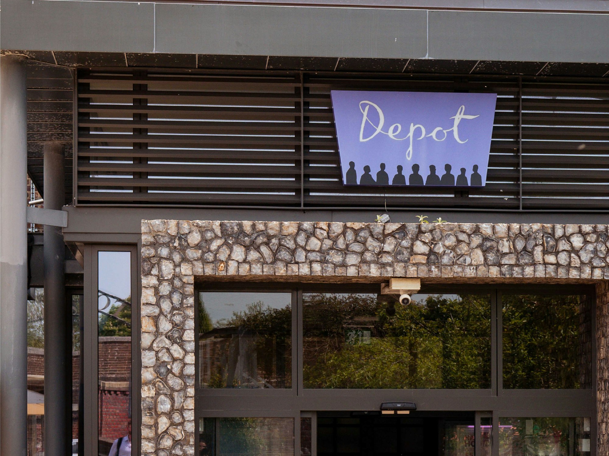 Depot cinema in lewes entrance way with their purple logo sign above the door.