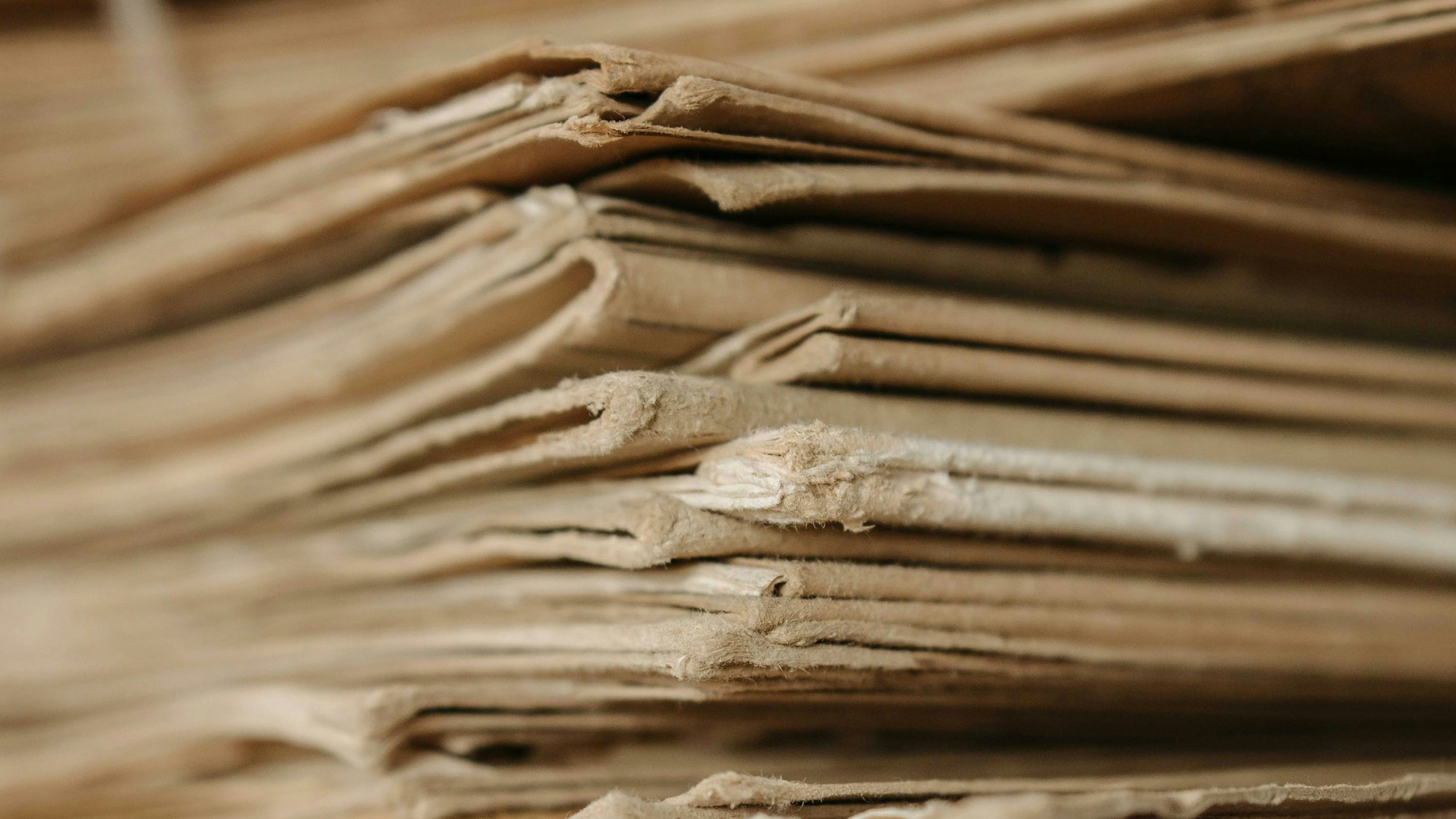 A pile of used cardboard on top of each other. The corners are worn down from their use.