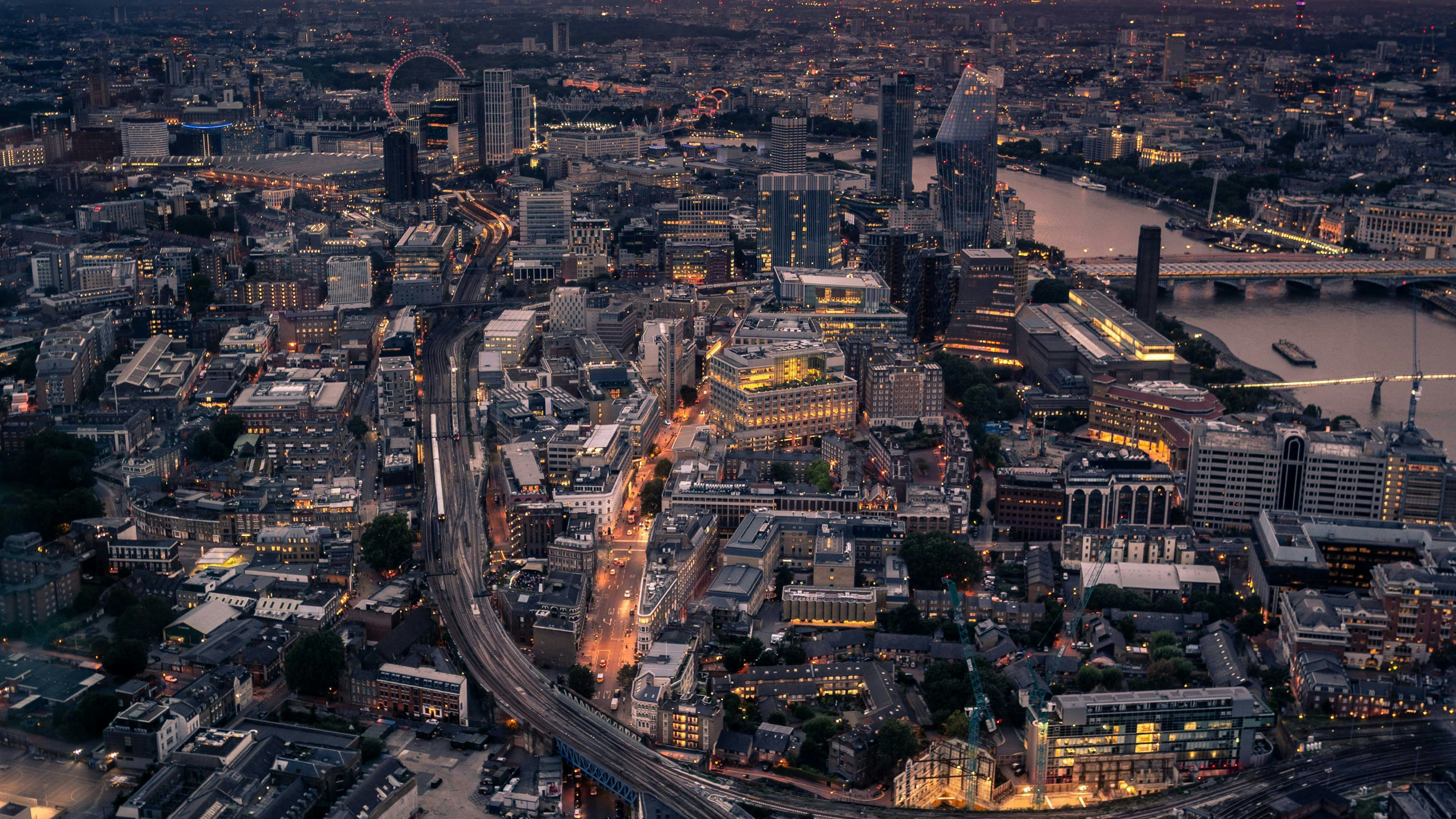 Birds eye view of London, specifically southwark. The Thames river along the right with the London Eye off into the distance.