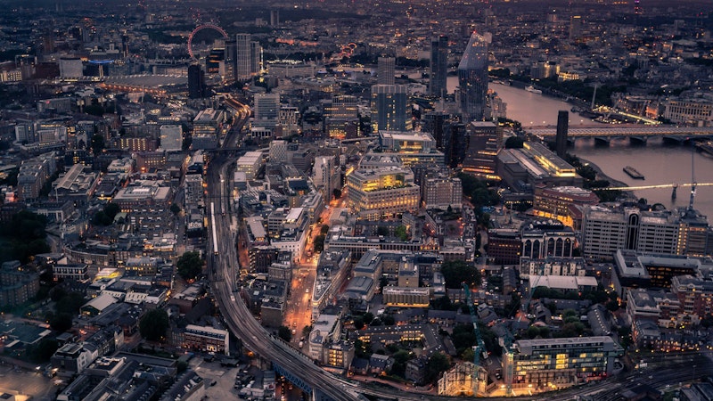 Birds eye view of London, specifically southwark. The Thames river along the right with the London Eye off into the distance.