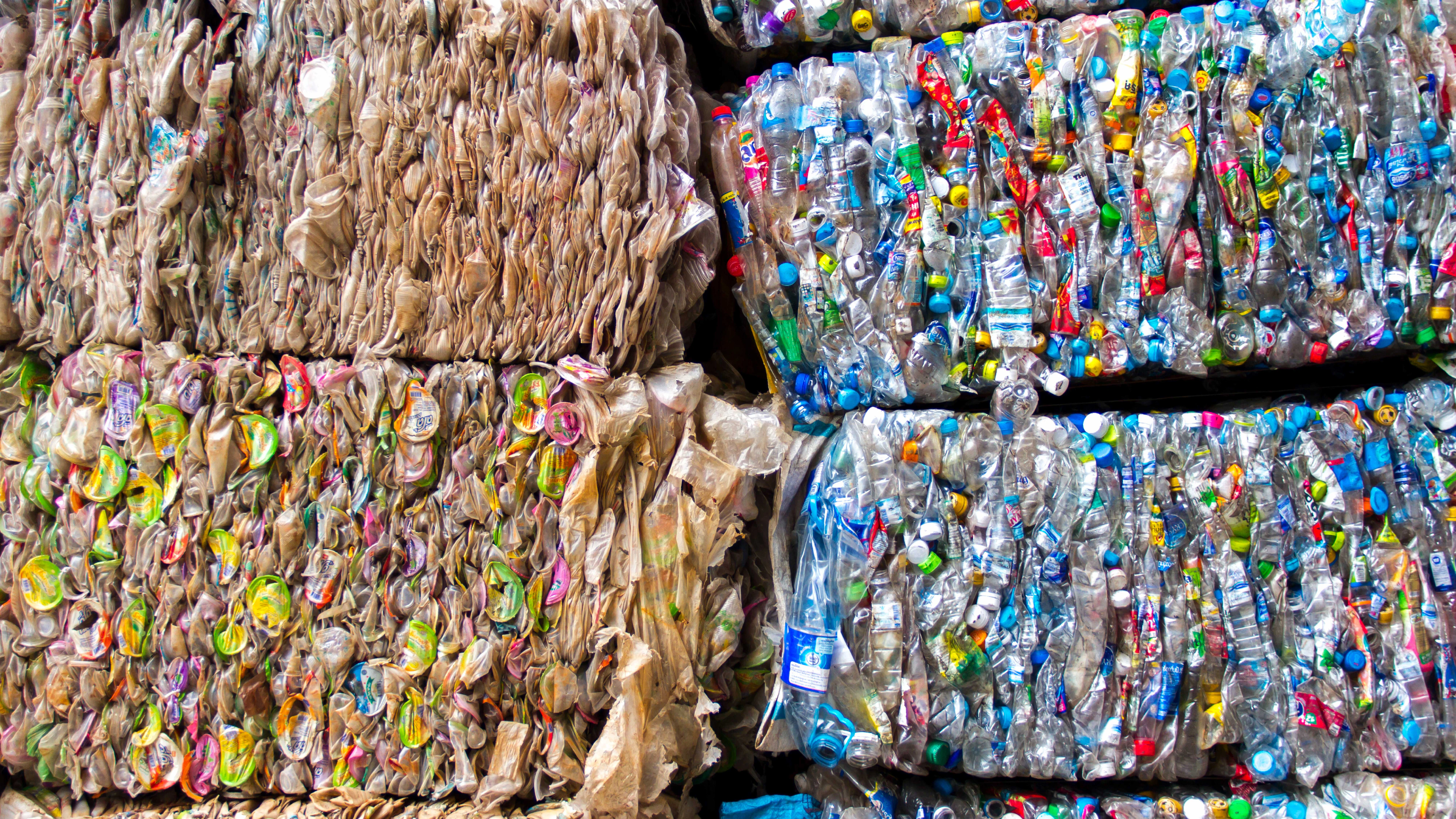 Baled Dry Mixed Recycling at the end of our MRF's process. On the left you can see 2 bales of cans stacked on top of each other. On the right you can see a plastic bottle bale.
