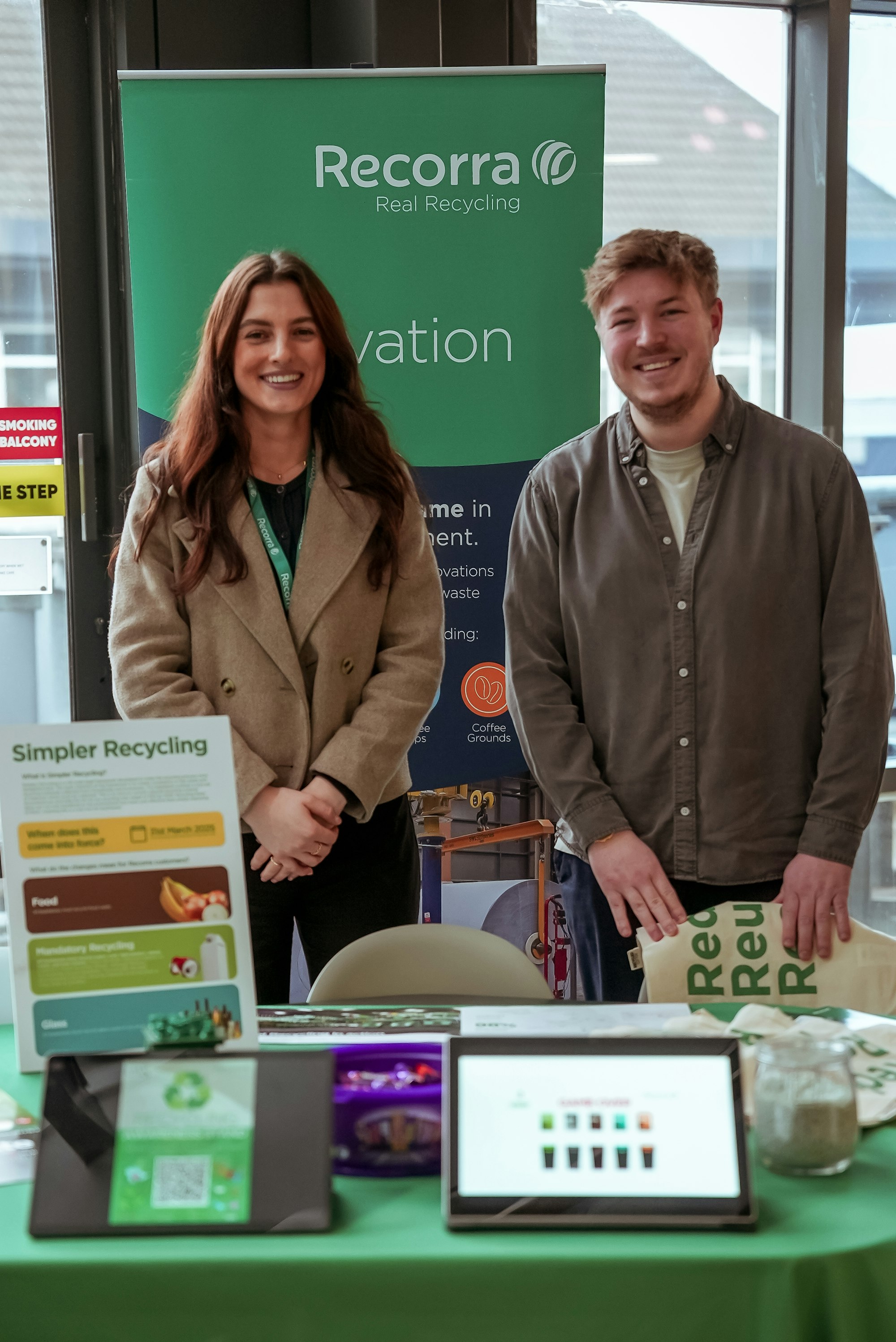 Recorra sustainability consultants at an awareness stand. Emily Wilson-North (left) and Nick Southwell (Right) are picture standing behind a table.