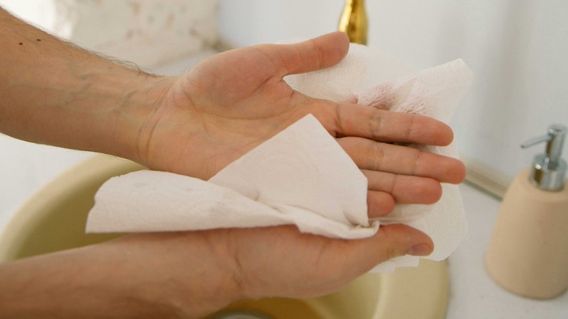 Hand drying with a paper towel, ready to be recycled.